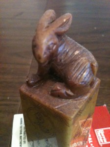 Brown carved stamp with a rabbit on top