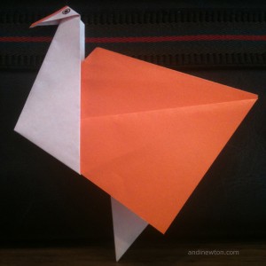 an orange and white origami bird