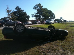 A Chrysler Sebring flipped on its roof with one wheel missing
