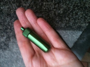 A person holding a green metal tube in her hand